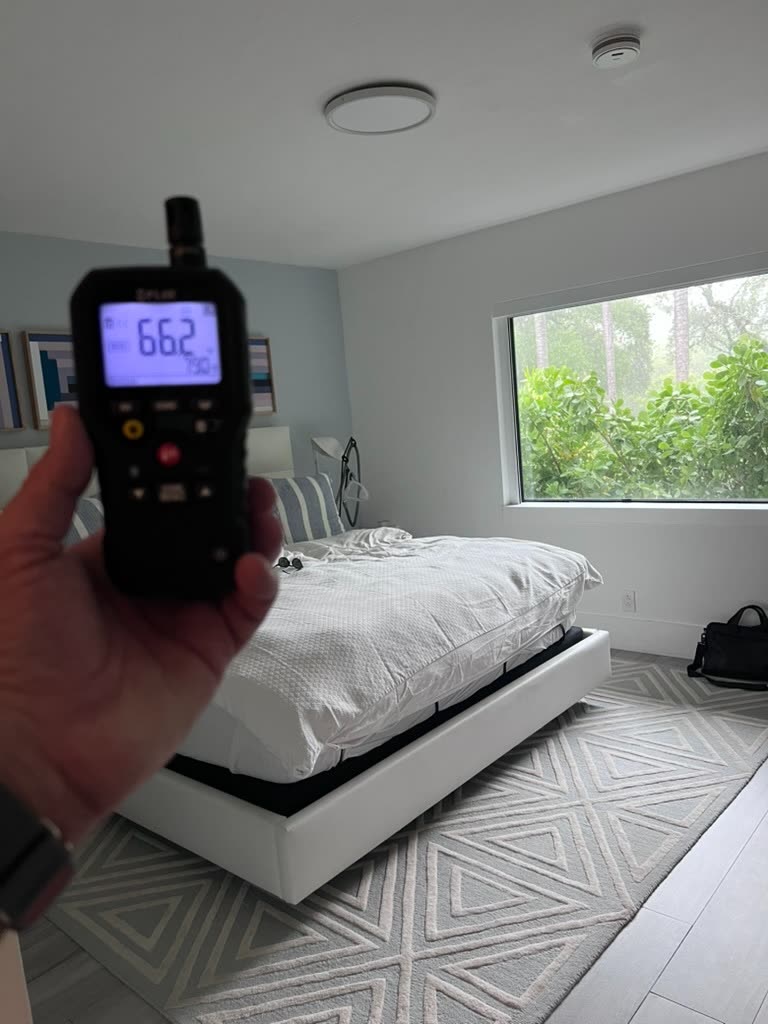 Thermo-hygrometer reading 66.2 degrees and 73 percent relative humidity in master bedroom during HVAC mold inspection