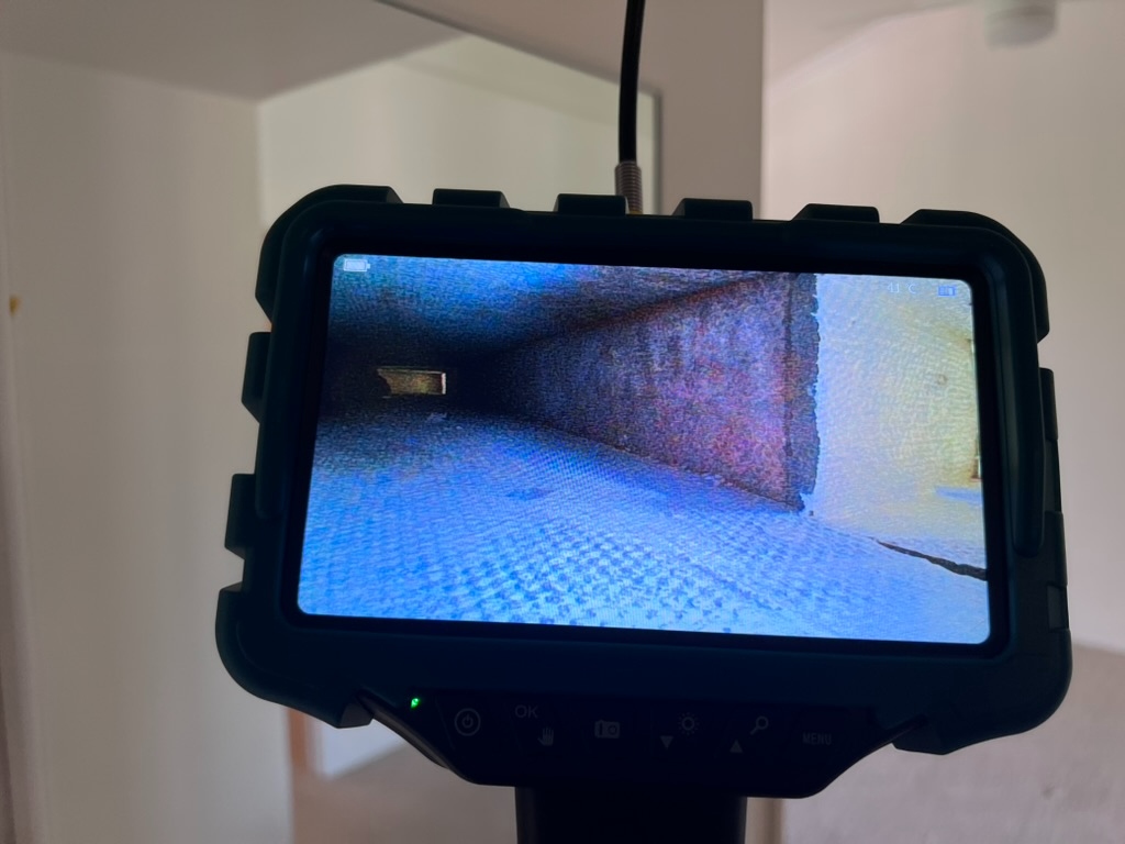 NIDAGE endoscope camera screen showing interior of an air duct with visible contamination and debris during HVAC mold investigation