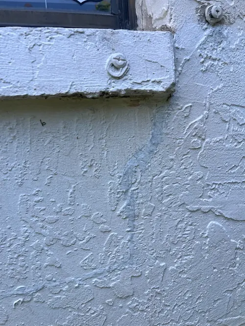 Exterior stucco crack extending from a window sill allowing water intrusion in Boca Raton, FL