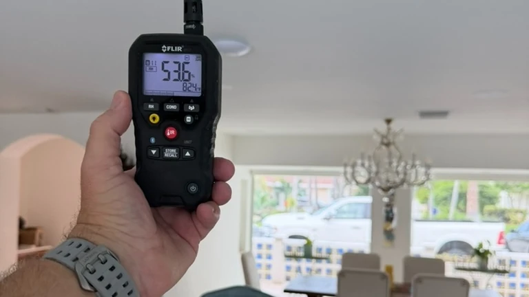 Digital humidity meter measuring relative humidity inside a residence
